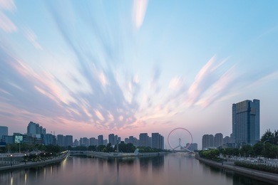 tianjin hai river waterfront downtown skyline with big ferris wheel named "tianjin eye",china.