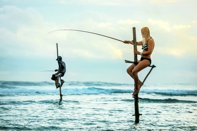 the european tourist catches fish in the traditional way. indian ocean. sri lanka.