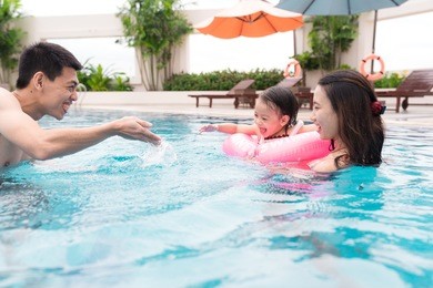 happy family in swimming pool. summer holidays and vacation concept