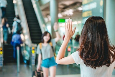 asian teen women greet her friends when her arrival at the airport.