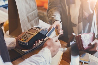 retail, credit card payment service. customer paying for order of cheese in grocery shop.