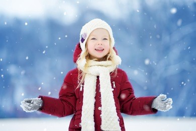 adorable little girl having fun in beautiful winter park. cute child playing in a snow. winter activities for kids.
