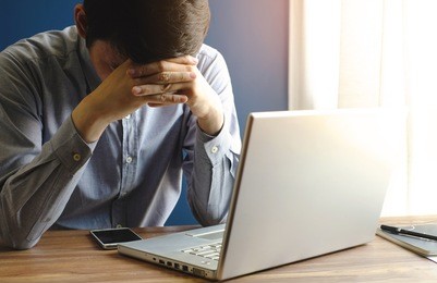 stressed businessman with laptop in office, dark tone, business concept