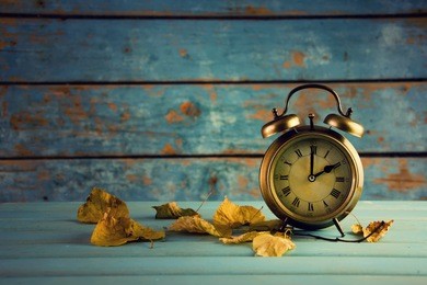 autumn time change, autumn leaves and alarm clock.