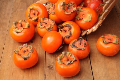 japanese fuyu persimmon on wooden background 