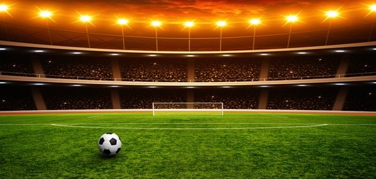 soccer ball on green stadium, arena in night illuminated bright spotlights