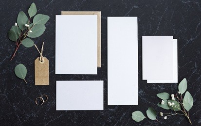 blank papers laying on marble table with leaves decoration