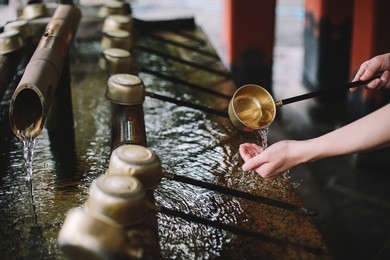 washing hands at temizuya water pavilion in a japanese temple