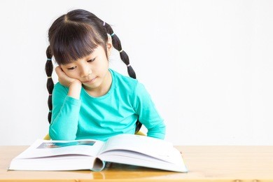 asian child read the book with boring.