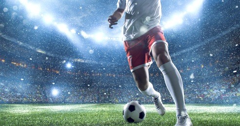 soccer player kicks the ball on the soccer stadium. he wear unbranded sports clothes. stadium and crowd made in 3d.