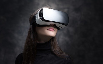 young woman wearing vr glasses and interacting with virtual reality, entertainment and innovative technology concept