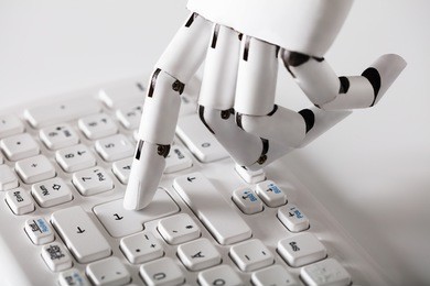 close-up of robotic hand pressing enter key on keyboard