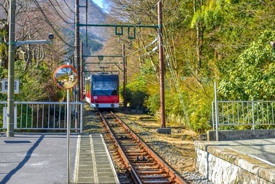 hakone tozan train is approaching the station .  
