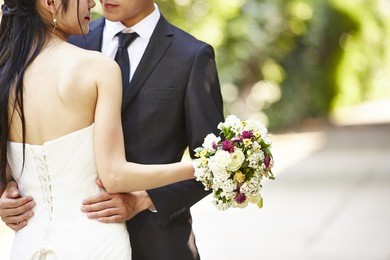 asian wedding couple hugging each other, focus on the bouquet.