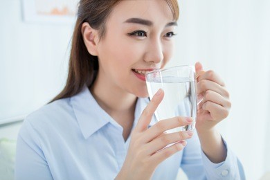young businesswoman drinks water on her workplace in office