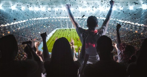 group of fans are cheering for their team victory