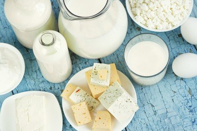 set of different dairy products on the blue wooden background, top view