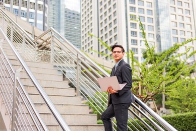 business man with his laptop going up the stairs  in a rush hour to work . hurry time.