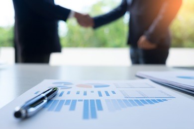 focus of business office desktop. young coworkers crew working with new startup project shake hand in modern loft.