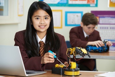 portrait of female pupil in science lesson studying robotics