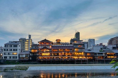 old house and restaurant in kamo river (kamogawa) at dusk, kyoto, japan       