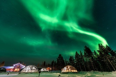 green powerful bright aurora above igloo house in finland
