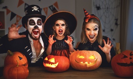 happy family mother father and child daughter  in costumes and makeup on a celebration of halloween

