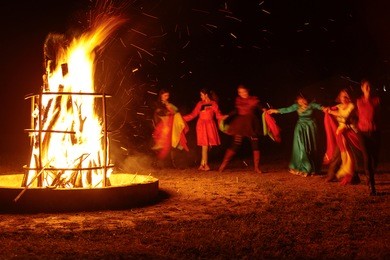 people dancing around the campfire 
