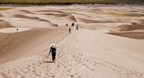 hikers on sand dune in great sand dune national park colorado