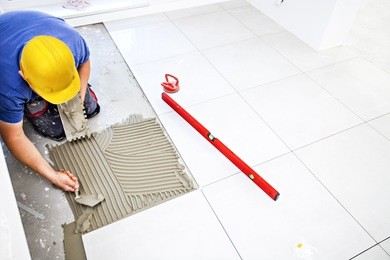 laying tiles at home. construction worker laid floor tiles.