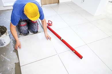 laying tiles at home. construction worker laid floor tiles.