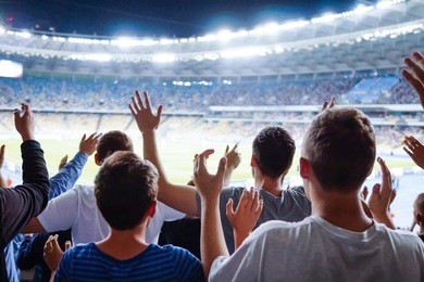 football- soccer fans support their team and celebrate goal in full stadium with open air with nice sky.-blur picture.