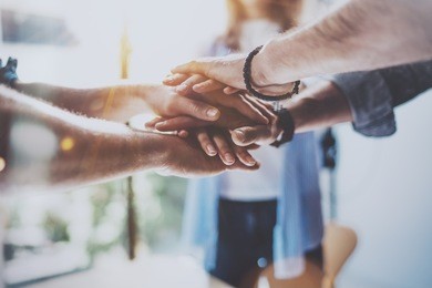 teamwork business concept.close up view of group of three coworkers join hand together during their meeting. horizontal.blurred background