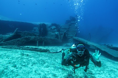 scuba diver shows the ok sign under water during a wreck dive in greece