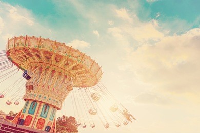 carousel ride spins fast in the air at sunset - vintage filter effects - a swinging carousel fair ride in amusement park at dusk