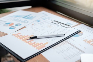 businesswoman working at his coffee shop and using laptop,  discussing the charts and graphs showing the results of their successful.