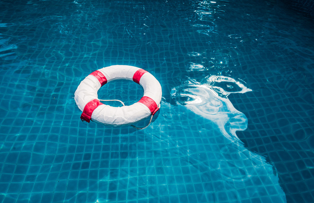 surface of transparent swimming pool water and life ring