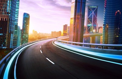 highway overpass motion blur with city skyline and urban skyscrapers , sunset and twilight scene.