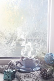 cozy soft gray blanket with a blue cup of coffee on the background of a window decorated with rain drop warming moments winter holidays  tonned photo