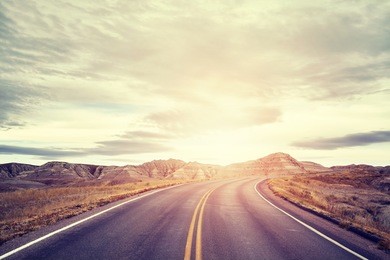 vintage toned picturesque road in badlands national park at sunset, travel concept background, south dakota, usa. 