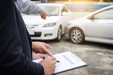 insurance agent examine damaged car and filing report claim form after accident, traffic accident and insurance concept.