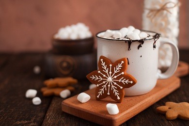 mug of hot chocolate or cocoa with christmas cookies and marsmallow on dark wooden background