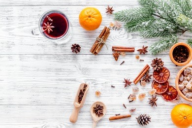 merry christmas in winter evening with warm drink. hot mulled wine or grog with fruits and spices on light background top view mock-up