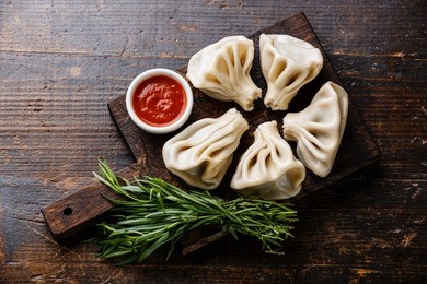 georgian dumplings khinkali with meat and tomato spicy sauce on cutting board