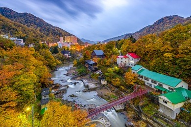 jozankei, hokkaido, japan inns and river skyline during the autumn season.