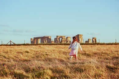 little gril running near stonehenge england travel destination vacation in south england, europe