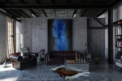 a contemporary, industrial polished concrete living room interior with leather lounges and modern art hanging. 3d rendering