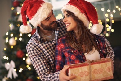 young cheerful couple in love with gift for christmas