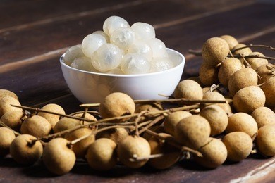longan, exotic fruit, with peeled longan on wooden table