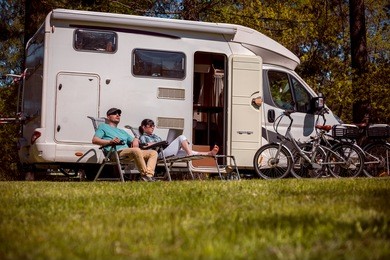 woman with a man resting near motorhomes in nature. family vacation travel, holiday trip in motorhome rv, caravan car vacation.